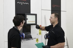 Two Zenith Tecnica staff members discussing an EBM machine